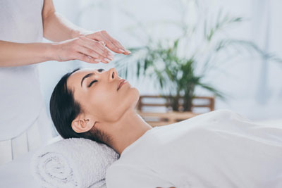 young-woman-with-closed-eyes-receiving-reiki-treatment-head